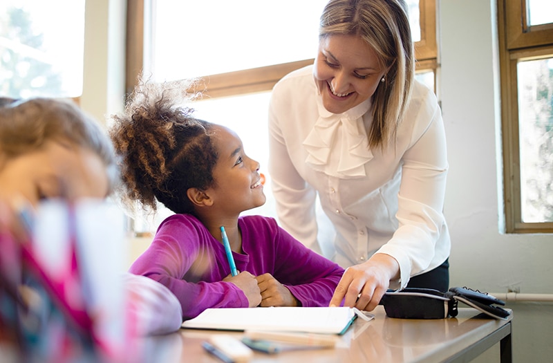 Woman on desk writing on calendar
