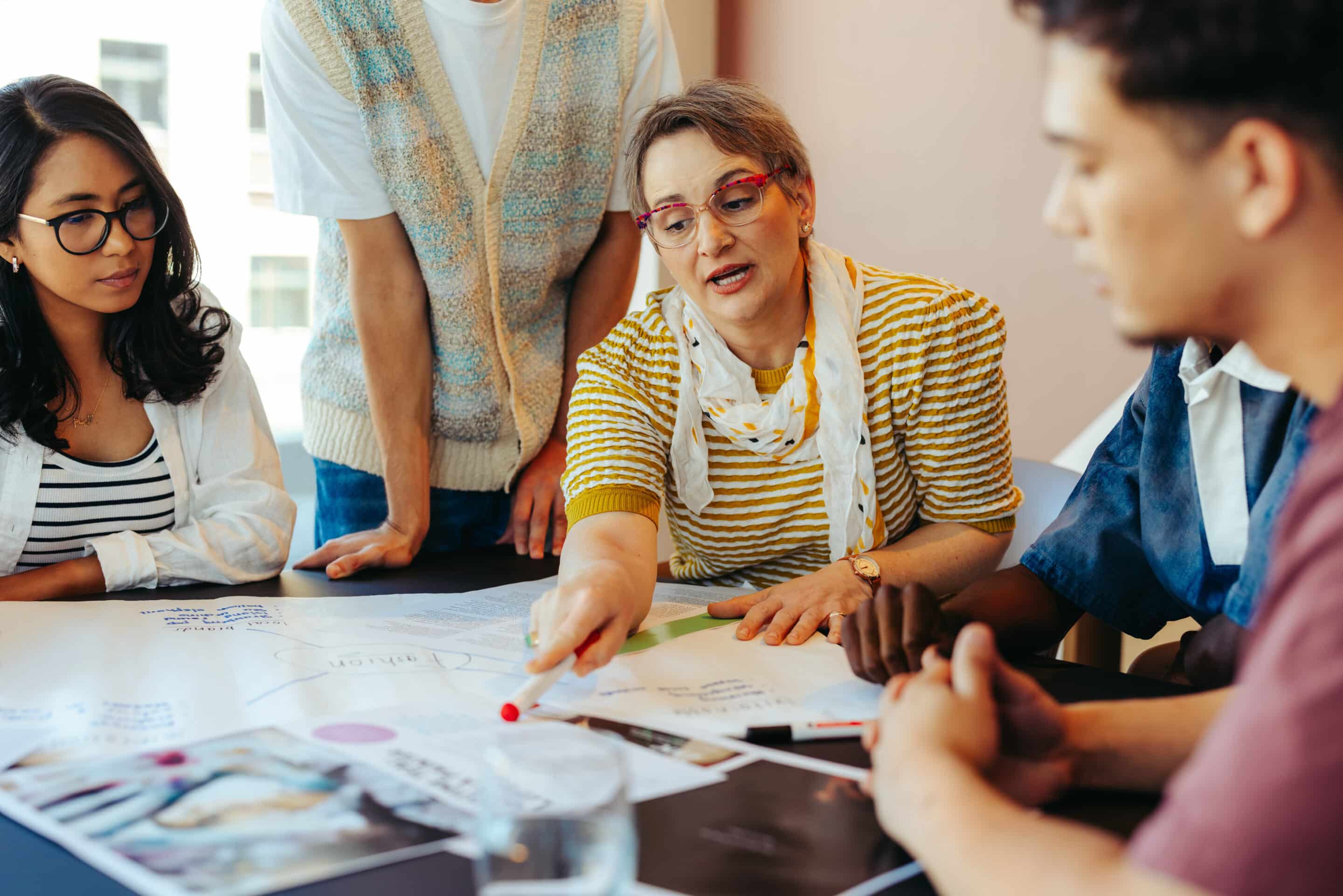 High school students collaborating with teacher in classroom for group project Teachers planning together
